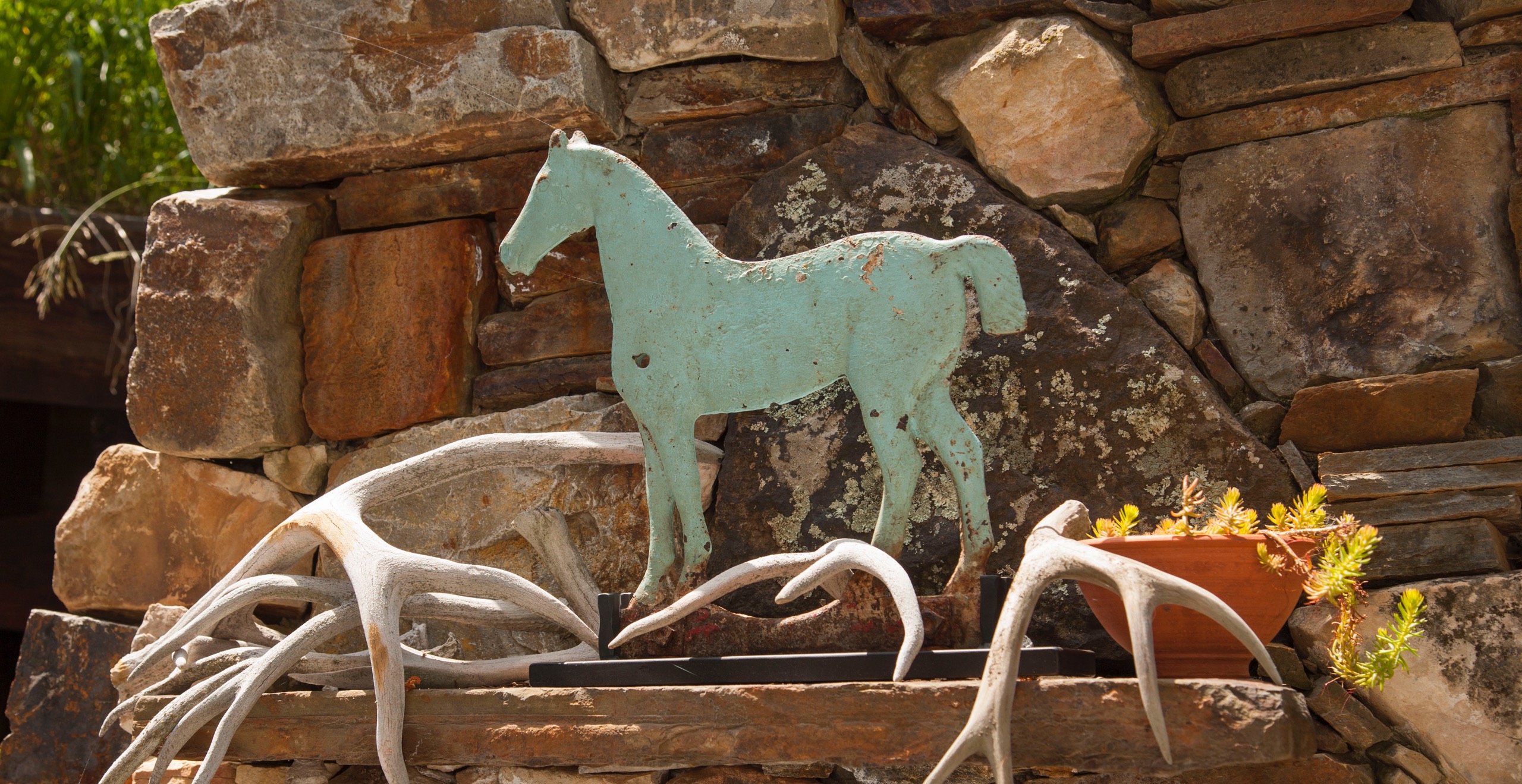 Buffy Birrittella’s rustic Utah getaway is home to all kinds of horses—the one she rides and the ones she collects. Here, a blue horse windmill weight surrounded by antlers
